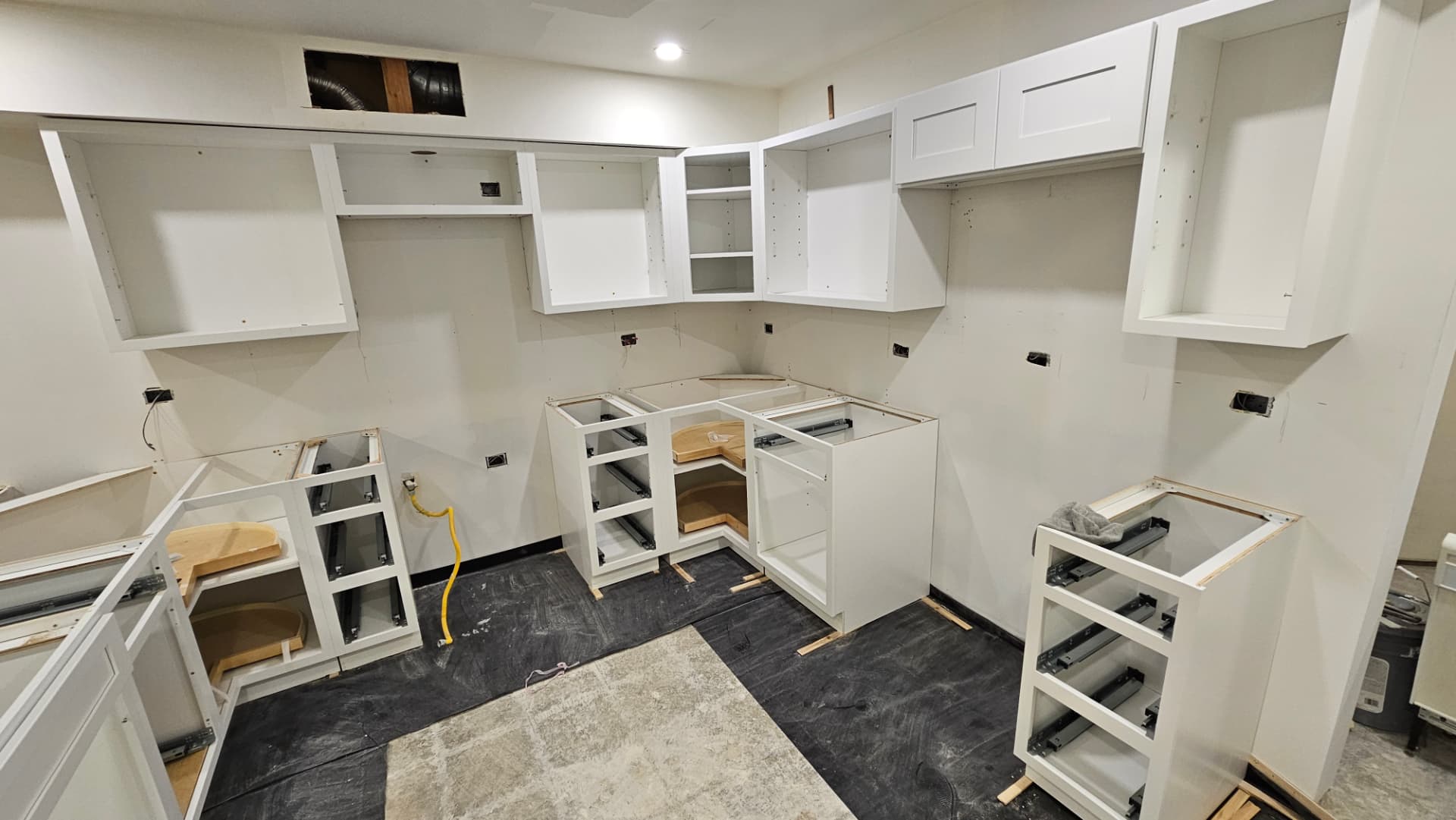 Kitchen mid-install with new cabinet boxes hung and set before counters and doors