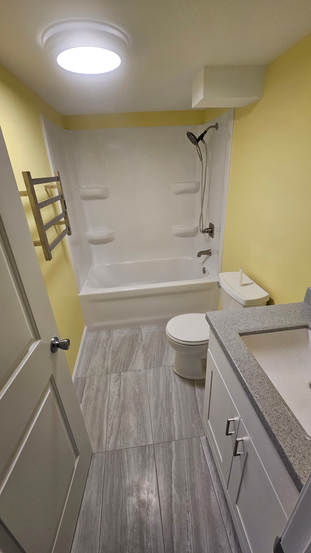 Updated bathroom with a new tub surround, tile floor and vanity
